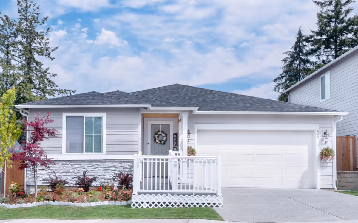 Single-story home with front porch, wreath, and a two-car garage.