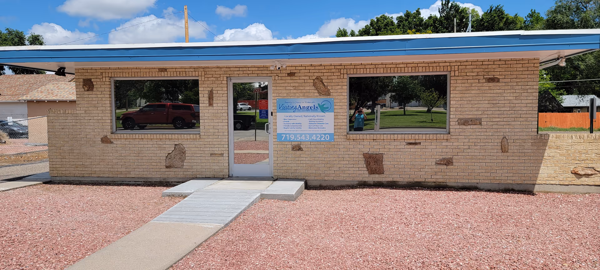 Single-story brick building with glass door, front windows, and Visiting Angels Senior Home Care signage.