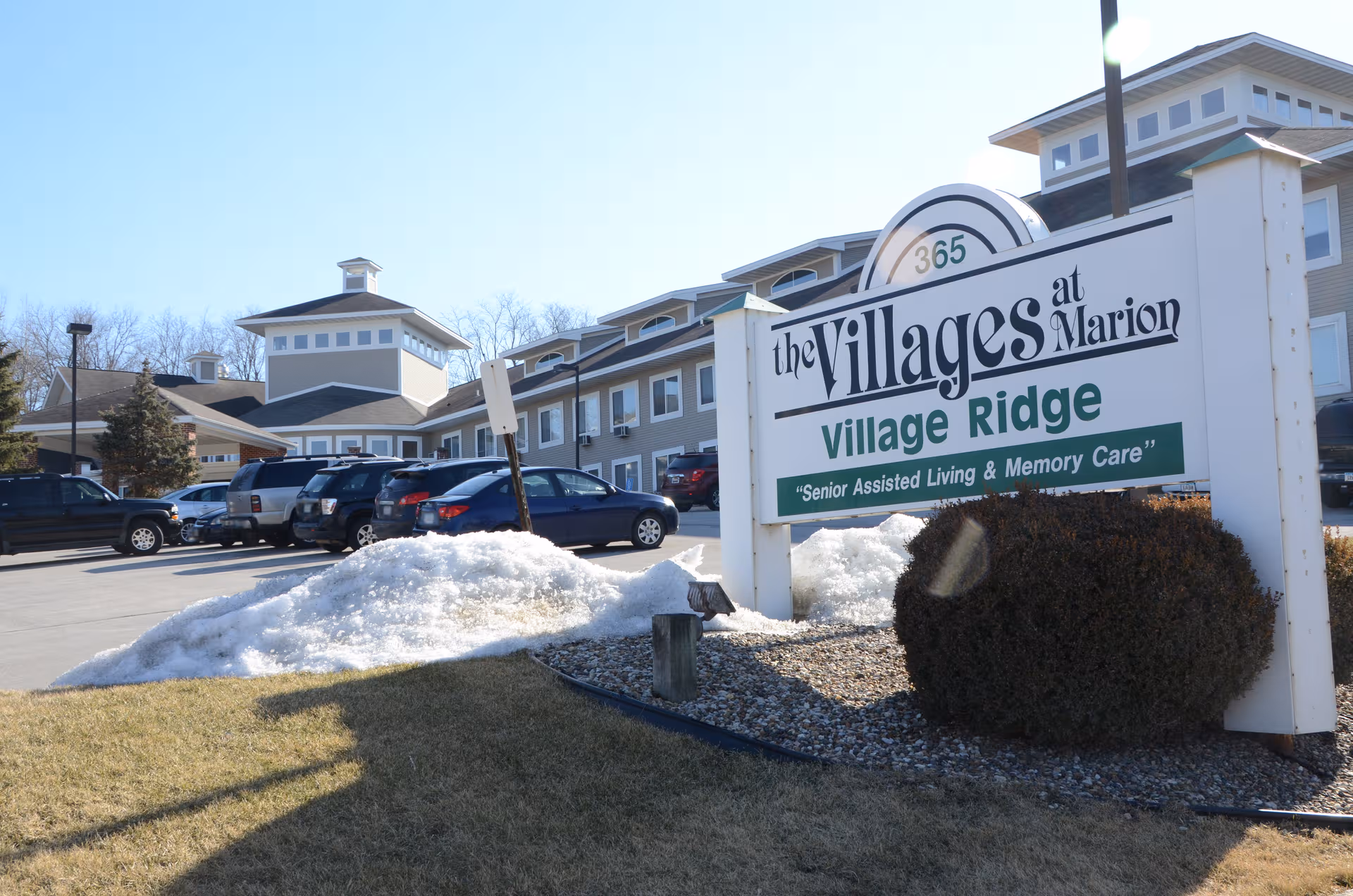 Exterior view of The Villages at Marion Village Ridge assisted living facility with sign and parking.