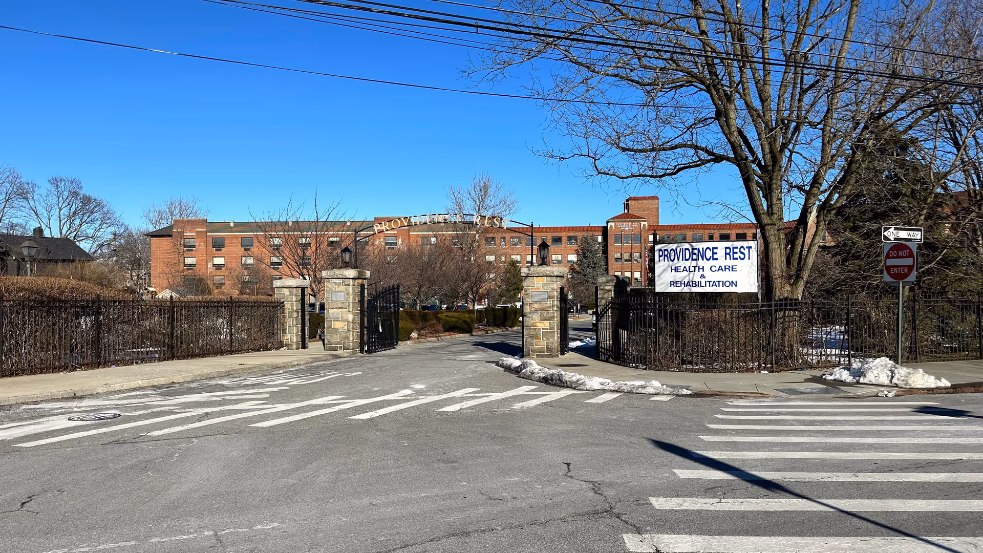 Gated brick senior care facility with stone pillars and a sign reading Providence Rest.