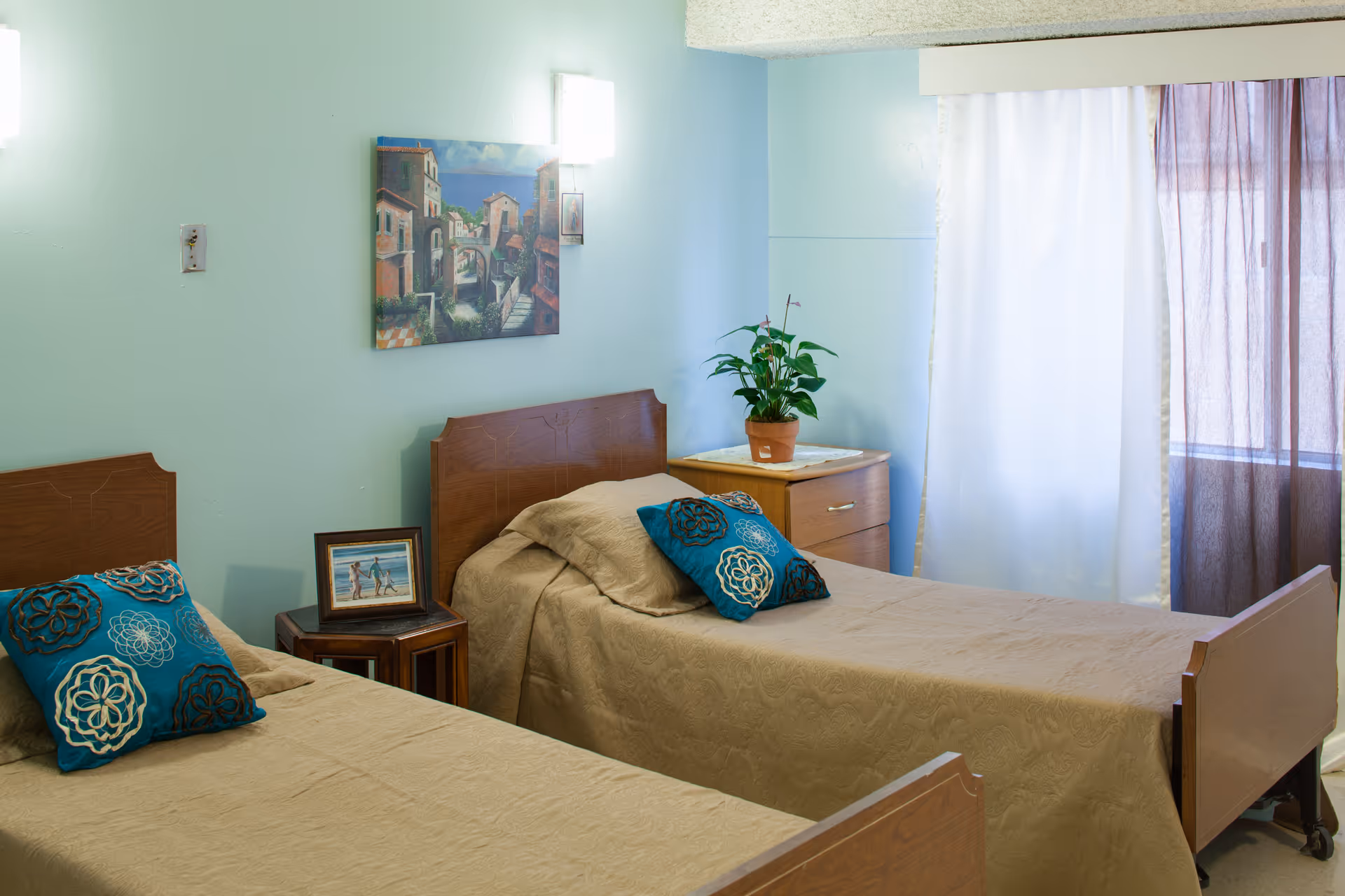Two twin beds with beige bedding and furniture in a pastel bedroom.