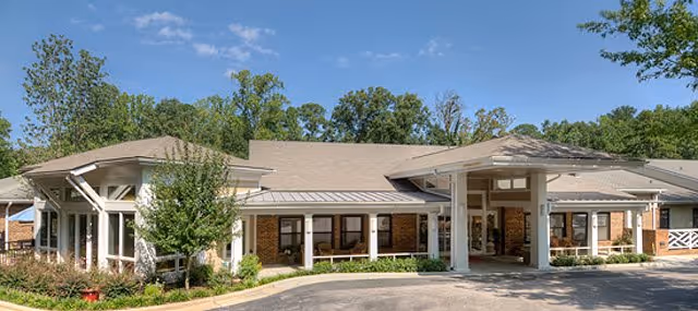 Single-story senior living facility with a covered entrance, brick facade, and well-kept landscaping.