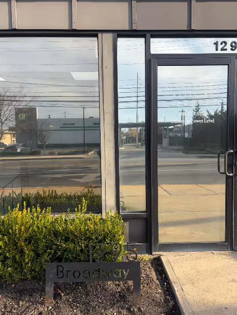 Exterior of a building with glass doors and a Broadway sign outside
