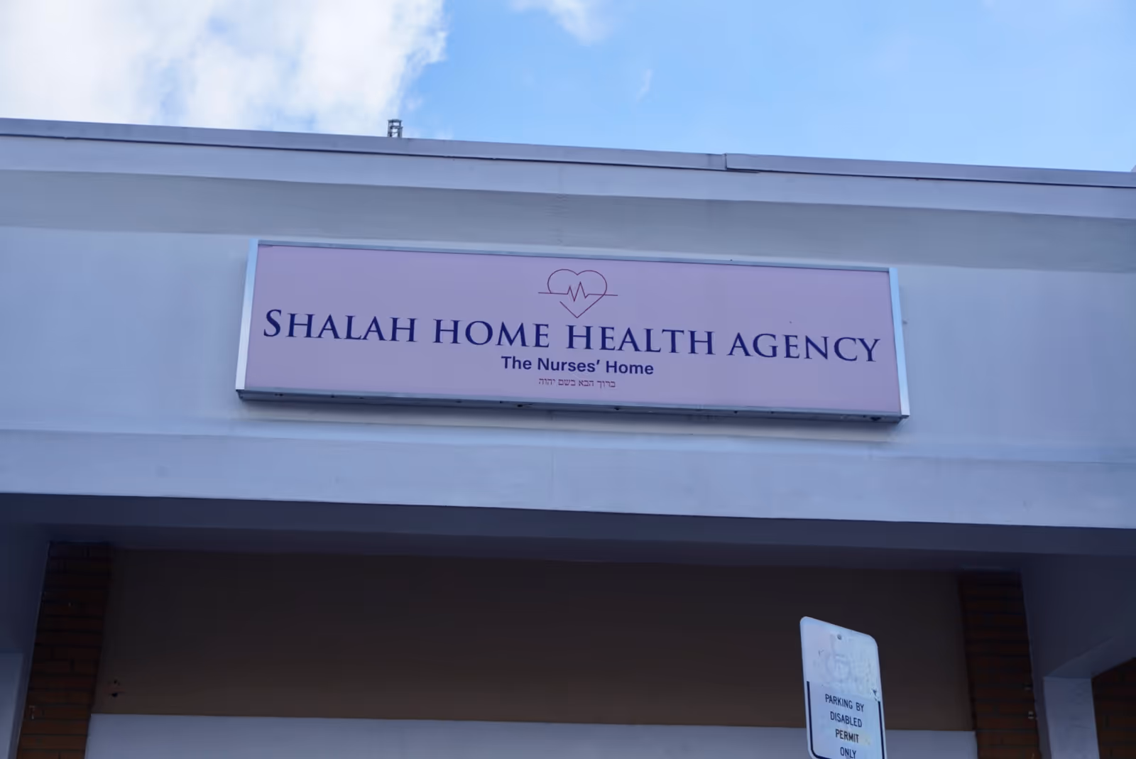 Exterior view of a building facade with a pink sign reading Shalah Home Health Agency.