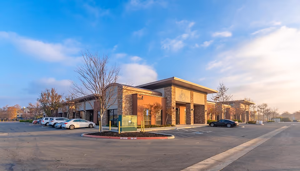 Exterior view of a senior living facility with a parking lot and entrance.