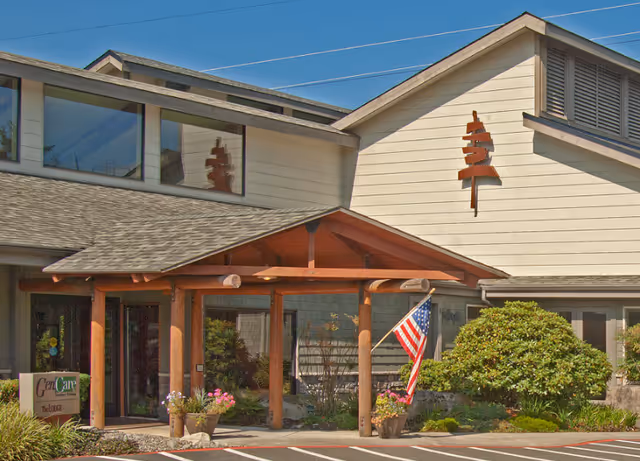 Front exterior of Stallworth Adult Foster Care with wooden entrance canopy and American flag
