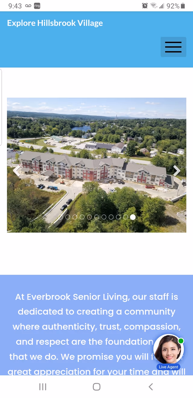 Aerial view of Hillsbrook Village senior living buildings surrounded by trees and parking.