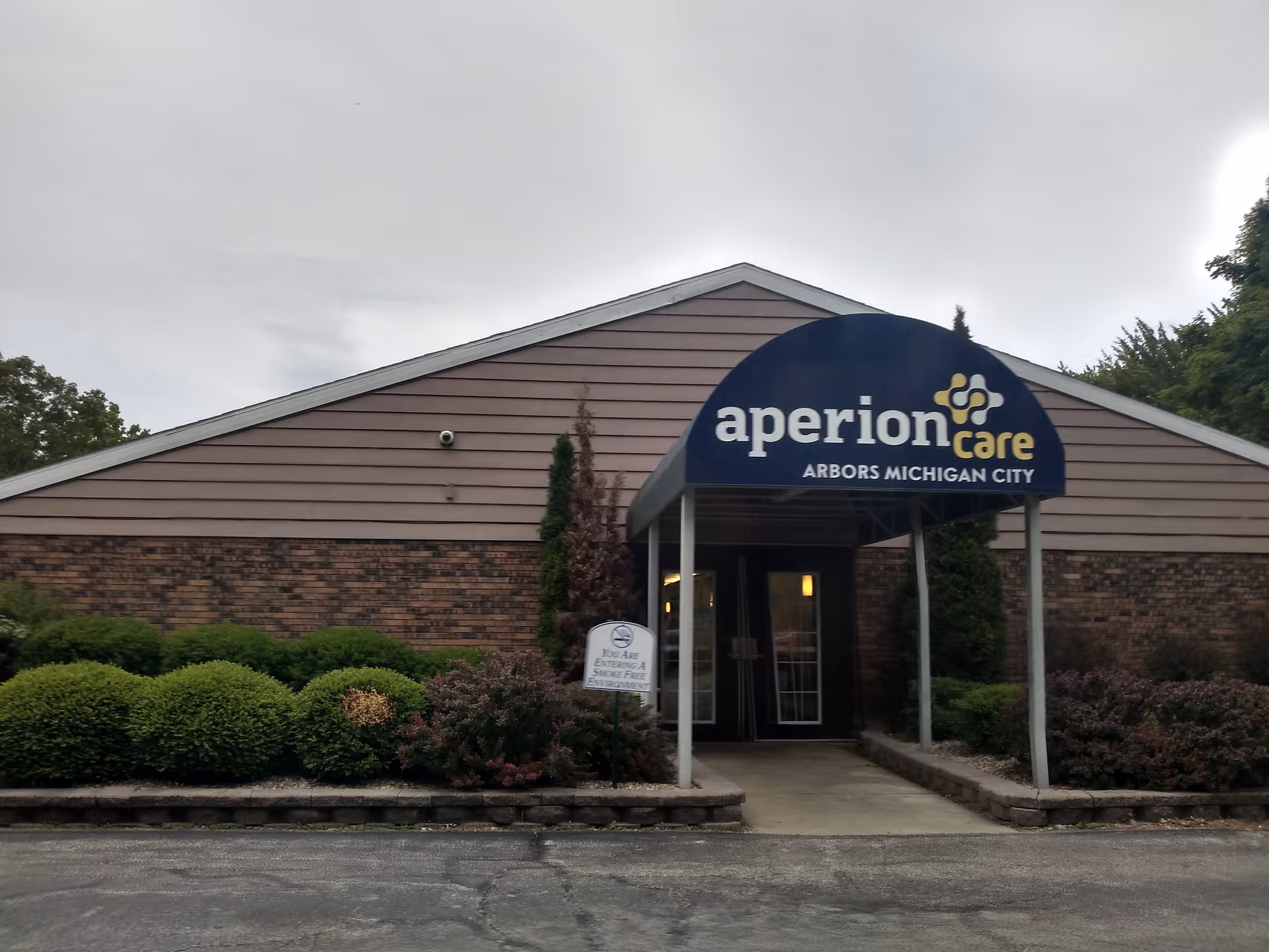 Aperion Care Arbors Michigan City building front with sign and entrance.