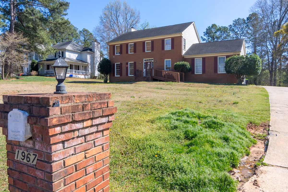 Brick two-story facility with front lawn, brick mailbox pillar, and driveway.