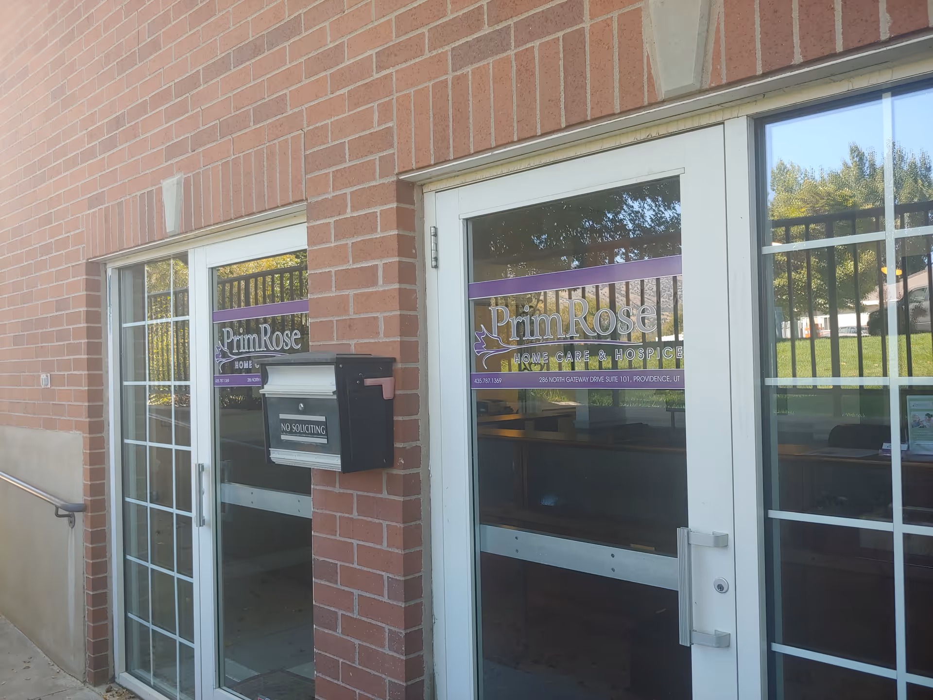 Brick building entrance with glass doors displaying PrimRose Home Care & Hospice.