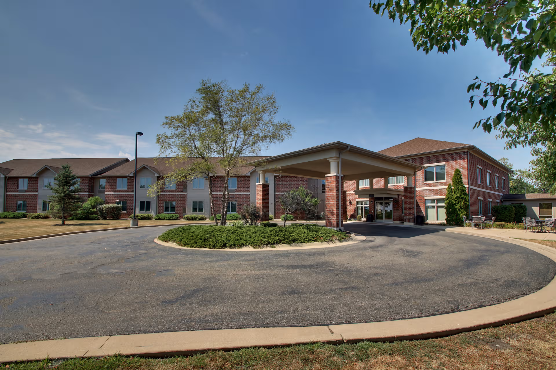 Evergreen Senior Living exterior: brick building, circular driveway, and covered entrance.