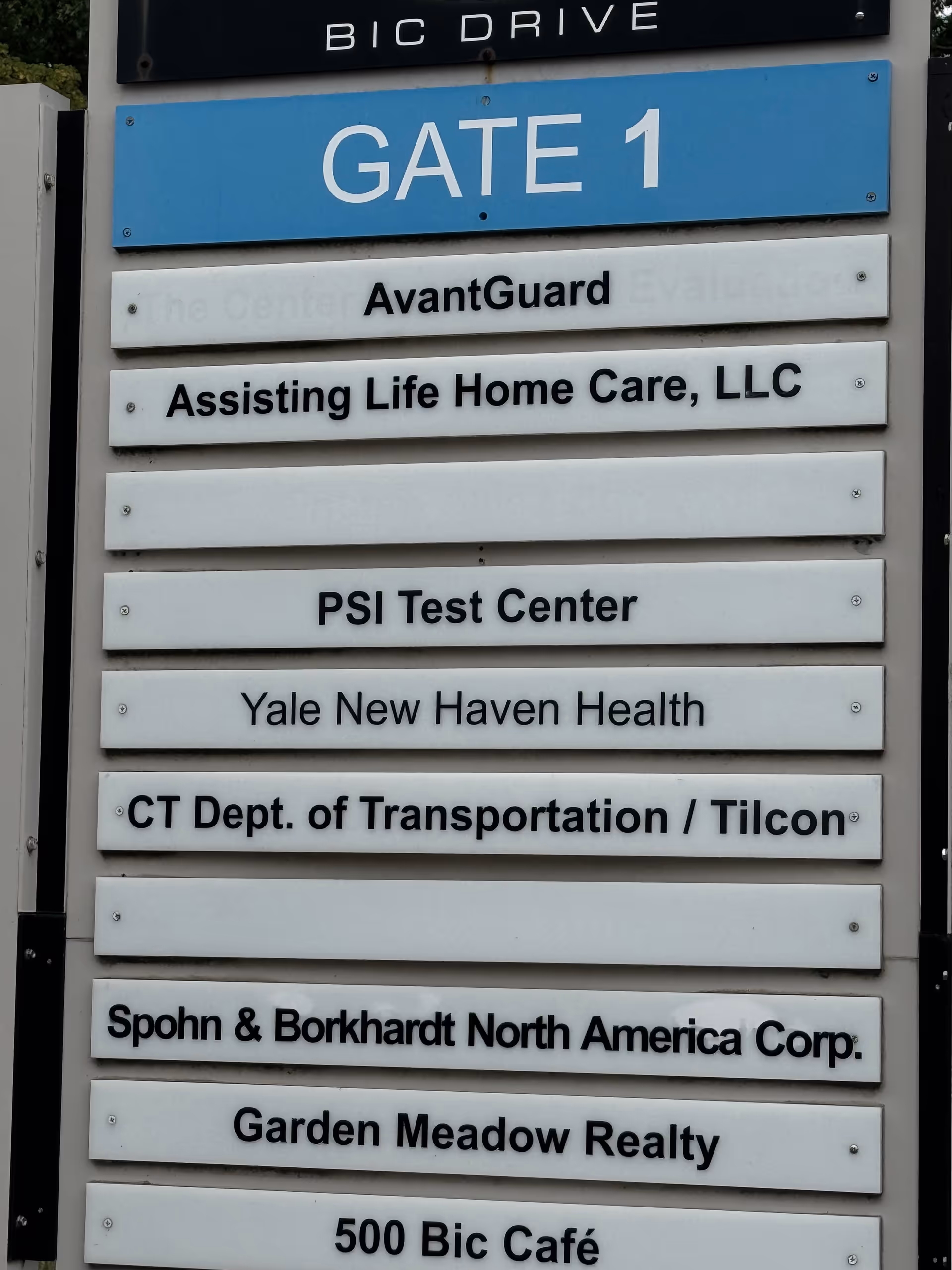 Tall outdoor signboard displaying Gate 1 and multiple tenant names including Assisting Life Home Care LLC.