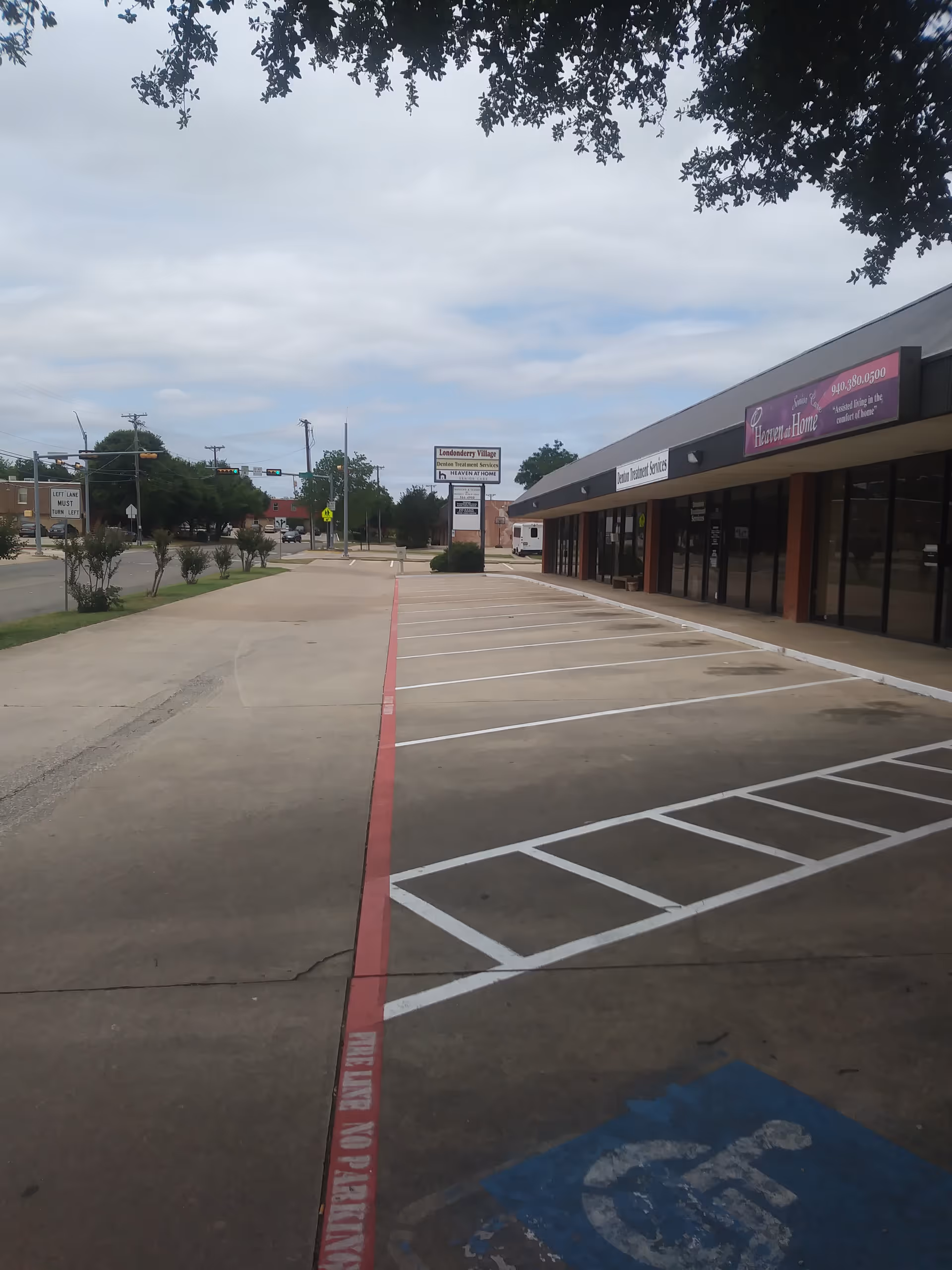 Exterior view of a strip mall with Heaven at Home Senior Care sign and parking.