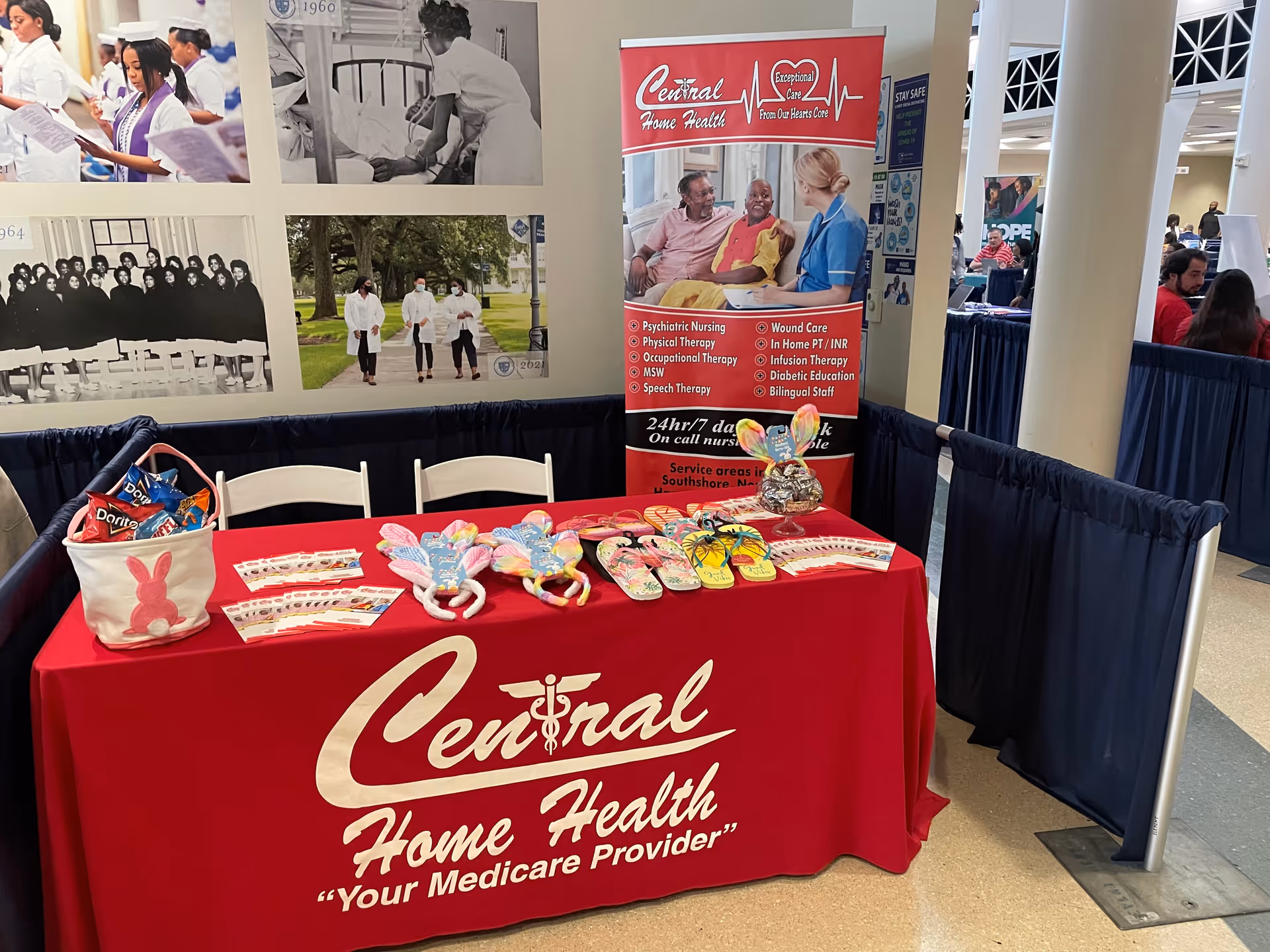 Indoor Central Home Health booth with red tablecloth, banner, and promotional items.