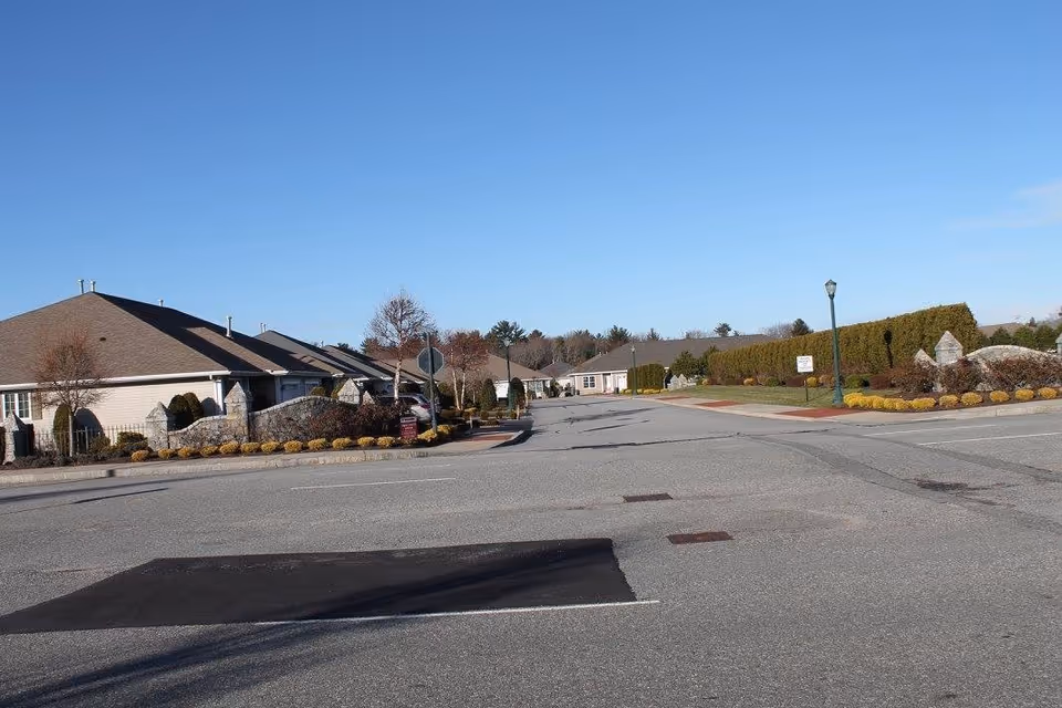 Quiet street view of Brookdale Centre of New England campus with single-story buildings.