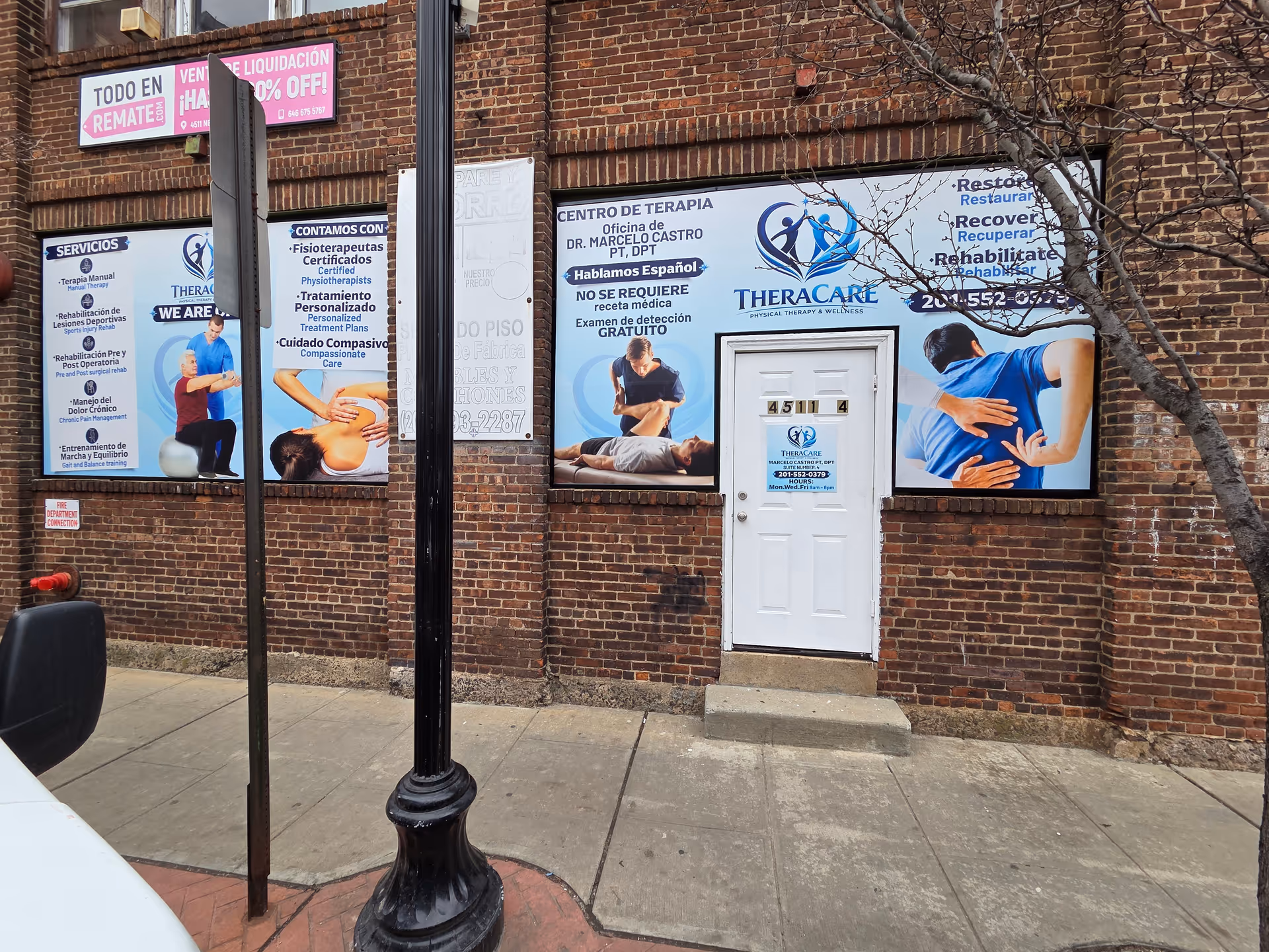 Brick building storefront with large TheraCare therapy banners and a white door.