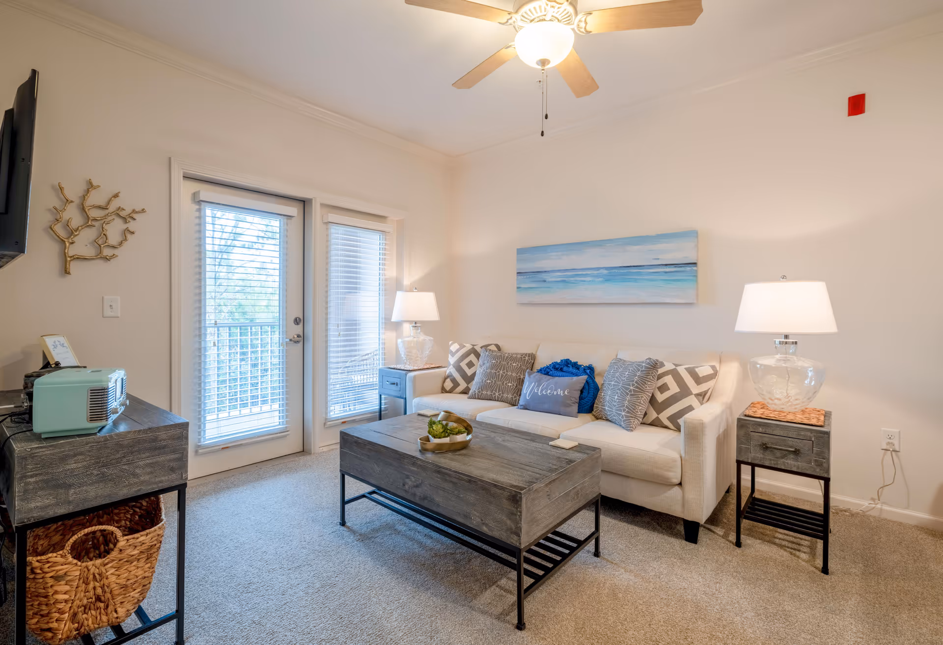 Cozy living room in a senior residence with sofa, coffee table, lamps, and glass doors.