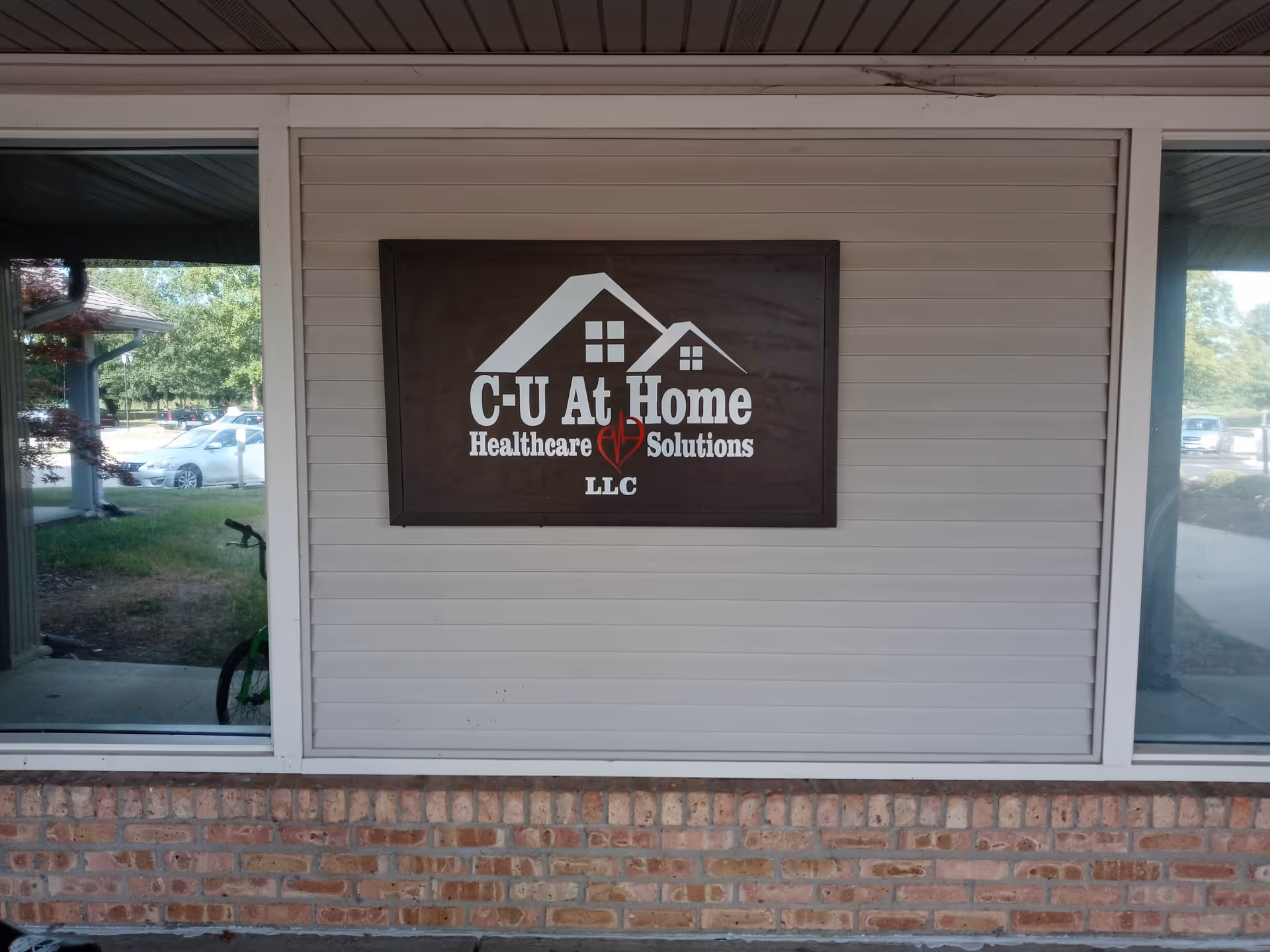 Exterior wall of C-U At Home Healthcare Solutions with a large sign.