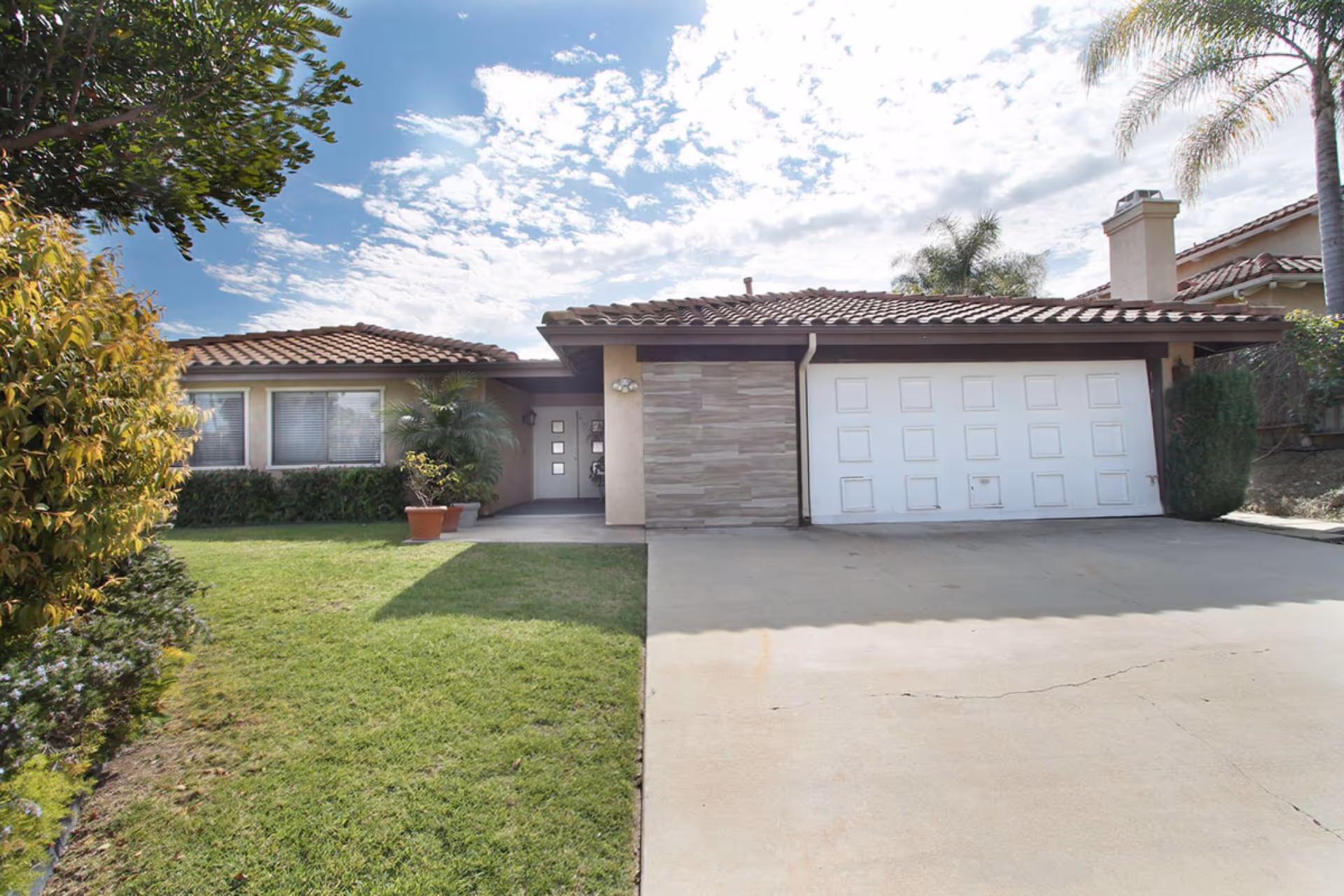 Front view of a single-story RCFE with a two-car garage and lawn.