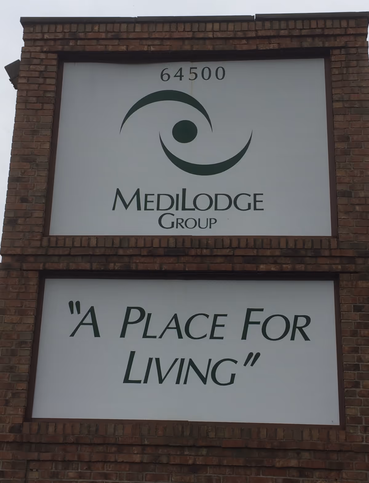 Brick sign with Medilodge Group logo and 'A Place For Living' slogan.