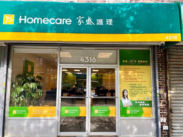 Green and yellow JS Homecare storefront with glass doors and interior desks, 4316.