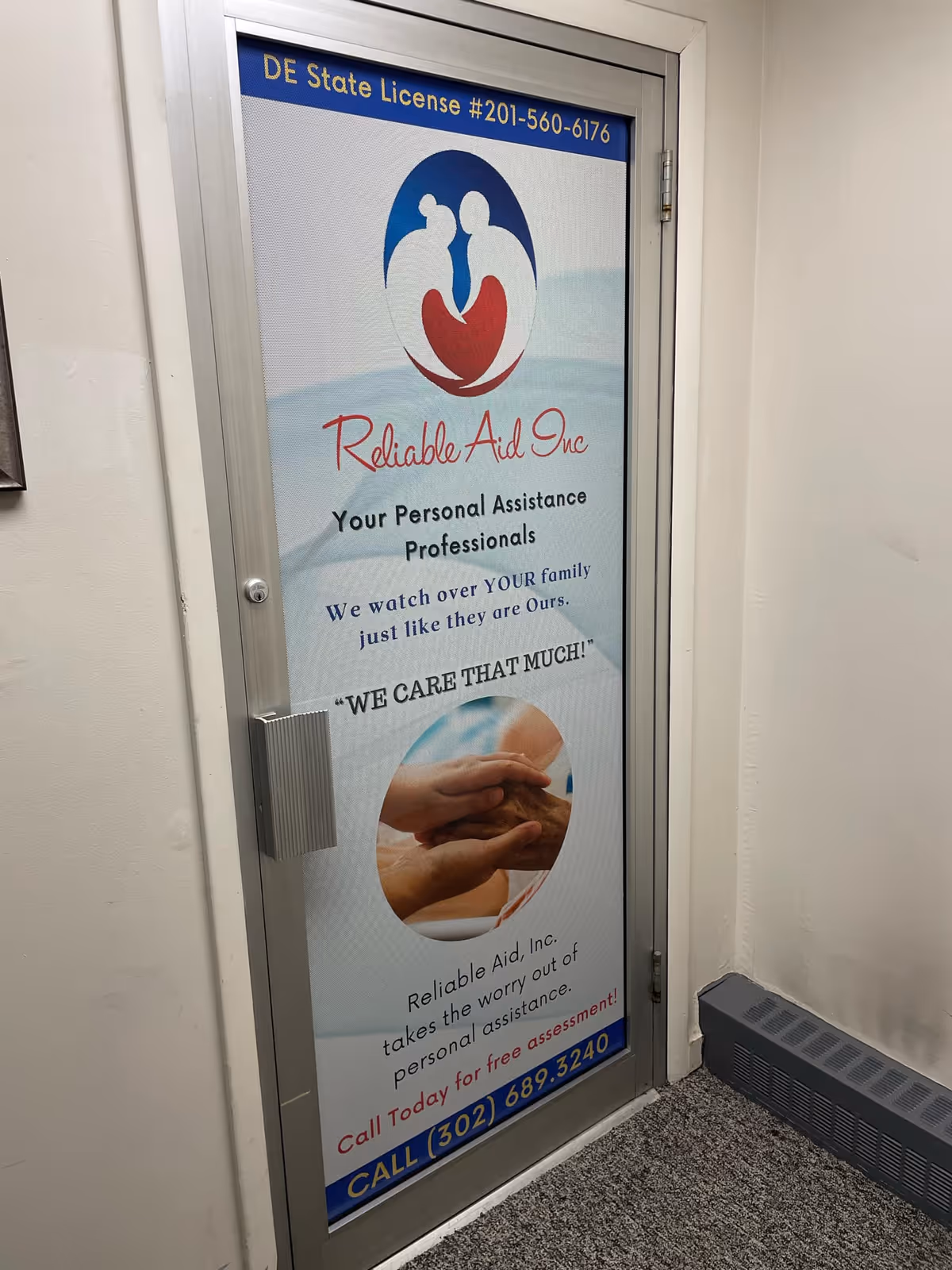 A door in a hallway displays the Reliable Aid Inc advertisement and logo.