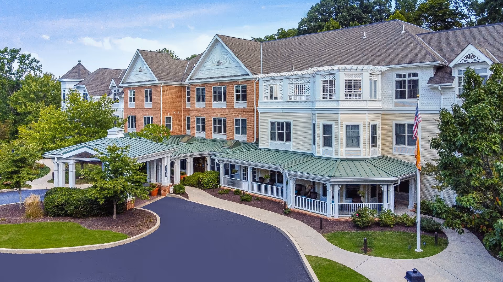 Exterior view of Sunrise of Newtown Square, a senior living community with a curved driveway.