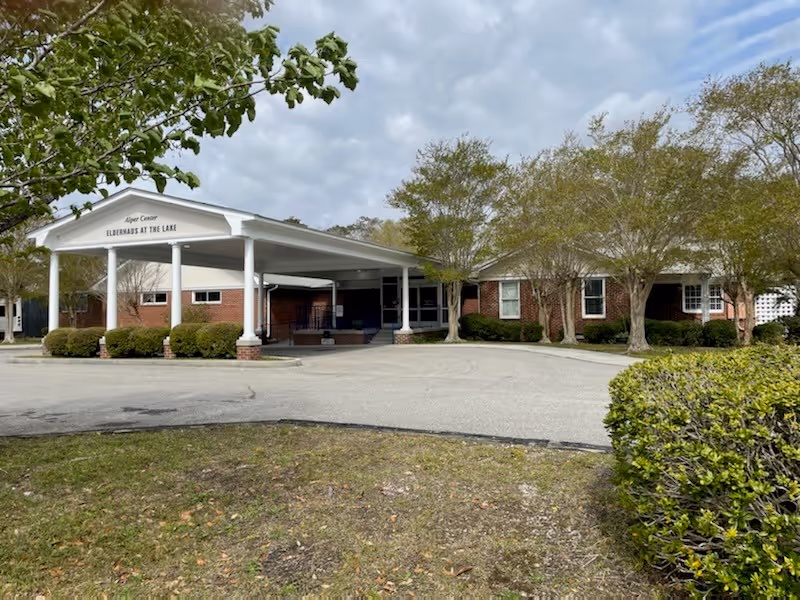 Brick senior living facility with a white covered entrance labeled Elderhaus at the Lake.