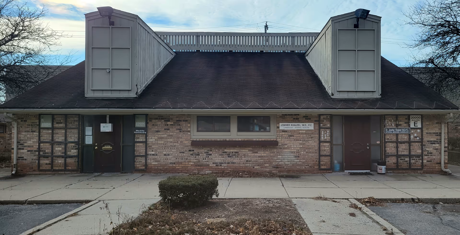 Front view of a single-story brick building with two large rooftop structures.