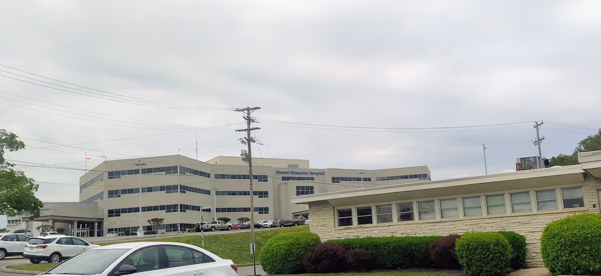 Exterior view of Blount Memorial health campus with parked cars.