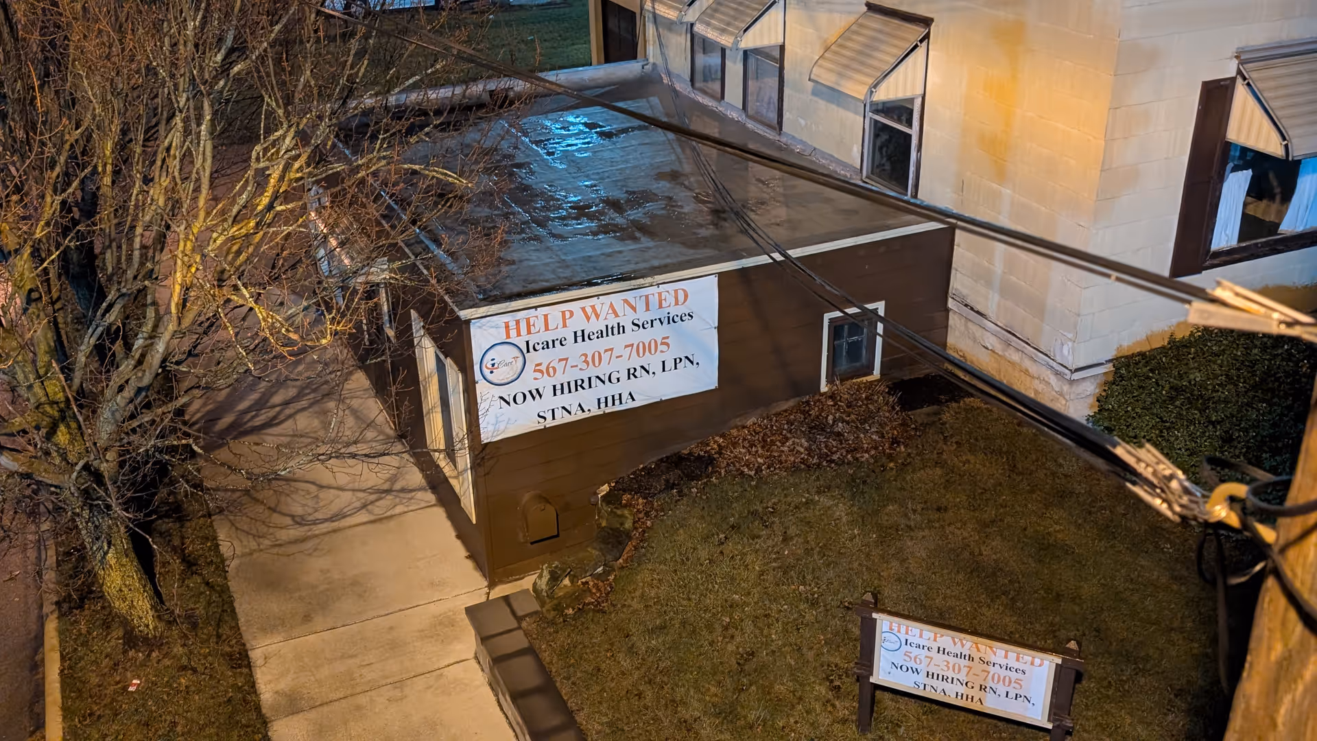 Exterior of iCare Health Services, LLC building with help wanted banner and lawn sign.