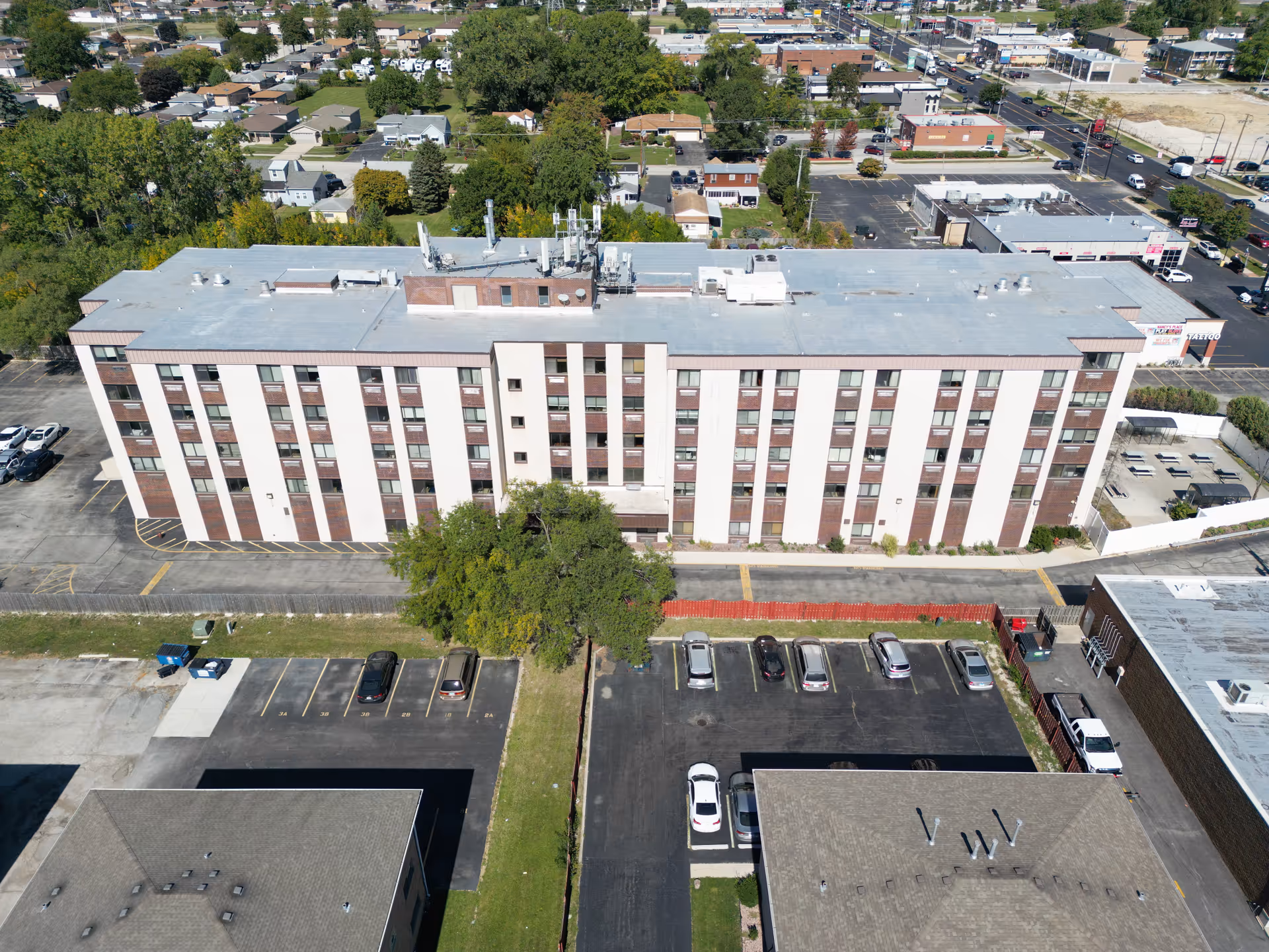 Aerial view of a multi-story senior living facility with parking lot and surrounding streets