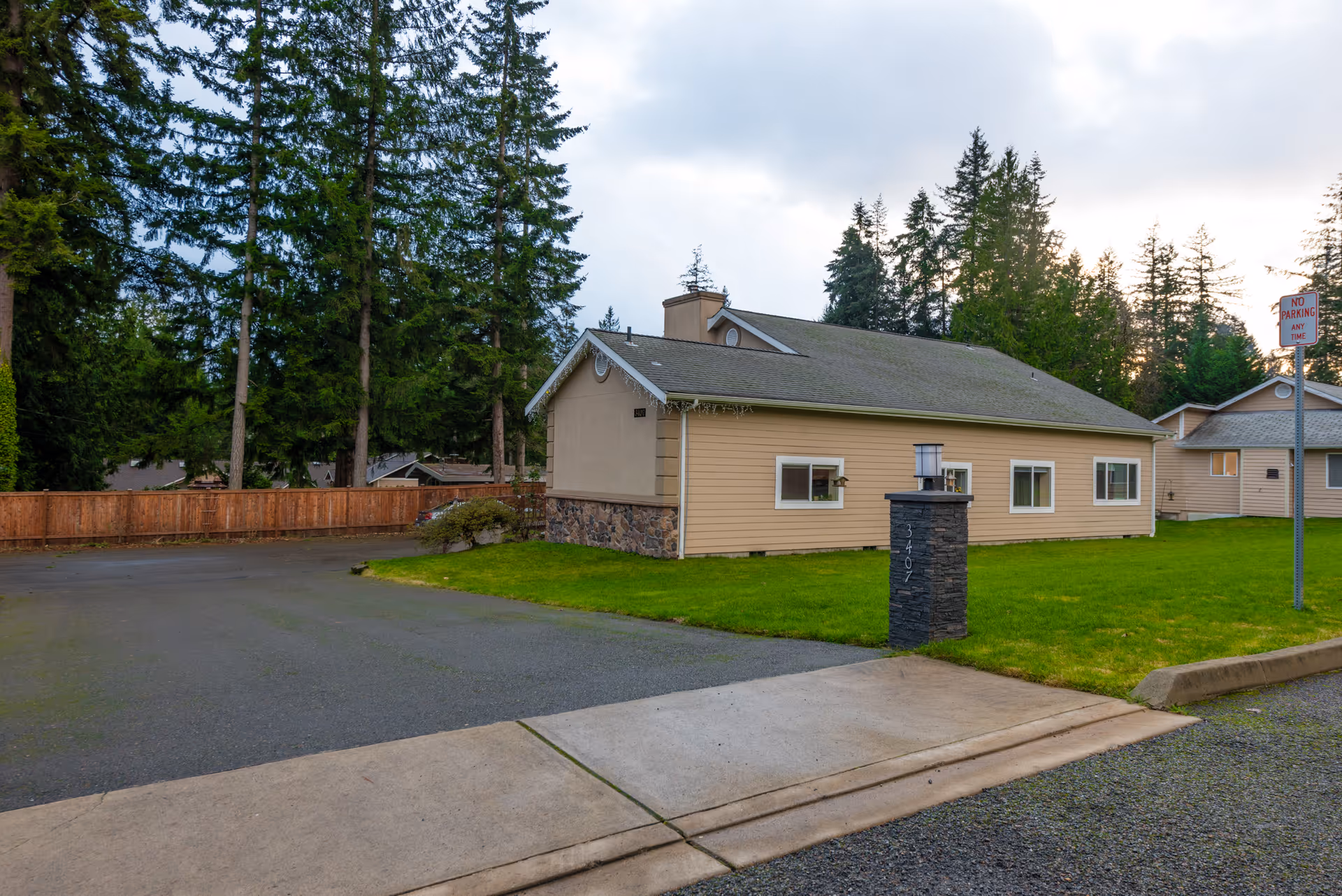 Exterior of Pine Lake AFH, a single-story beige building with lawn and trees.
