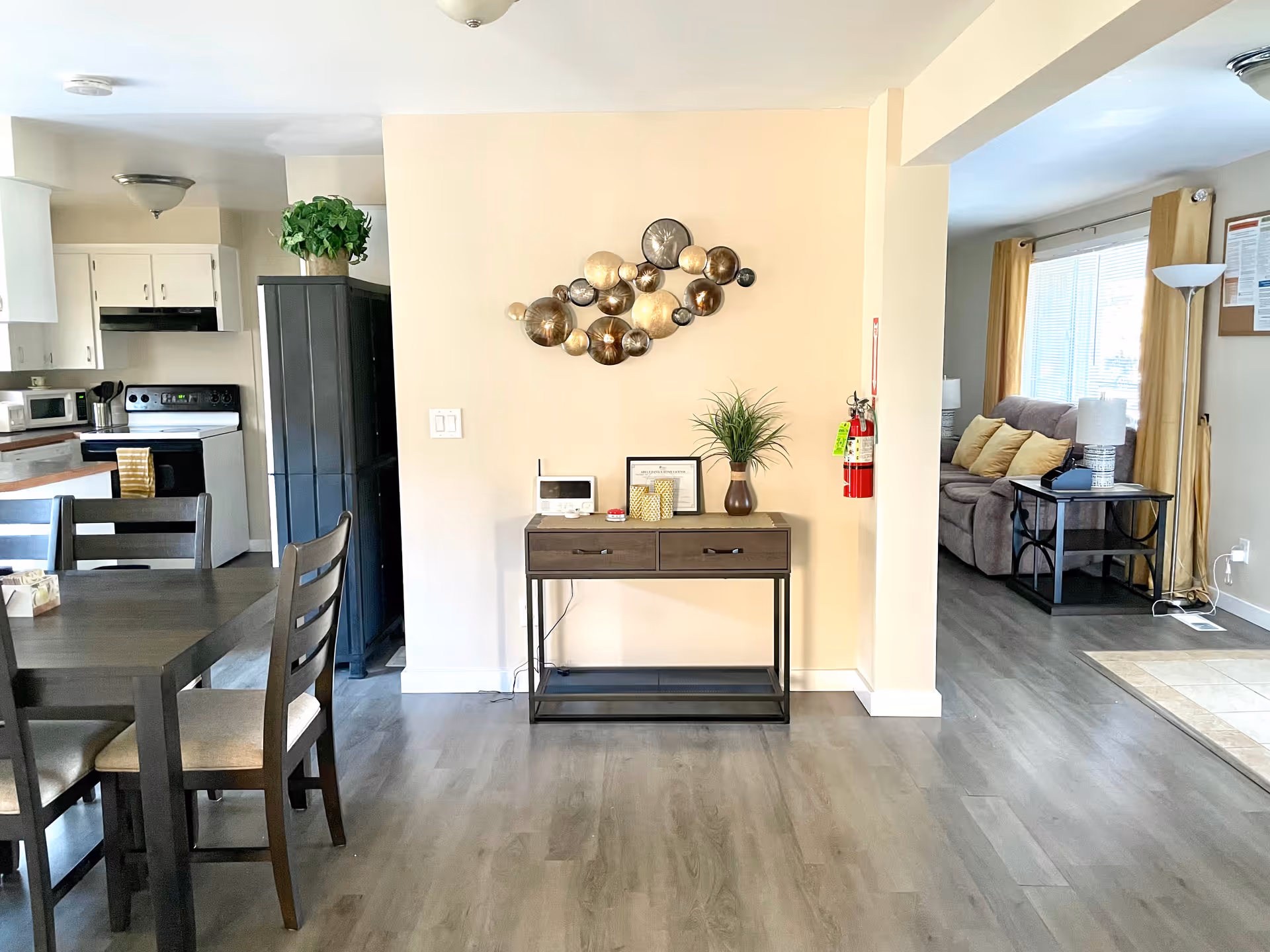 Open living area with dining table, kitchen to the left, and sofa in back.