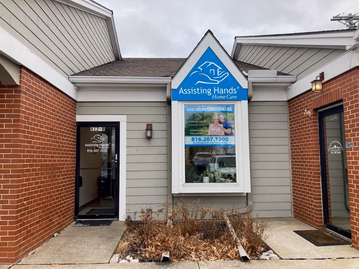 Exterior storefront of Assisting Hands Home Care with entrance doors and sign.