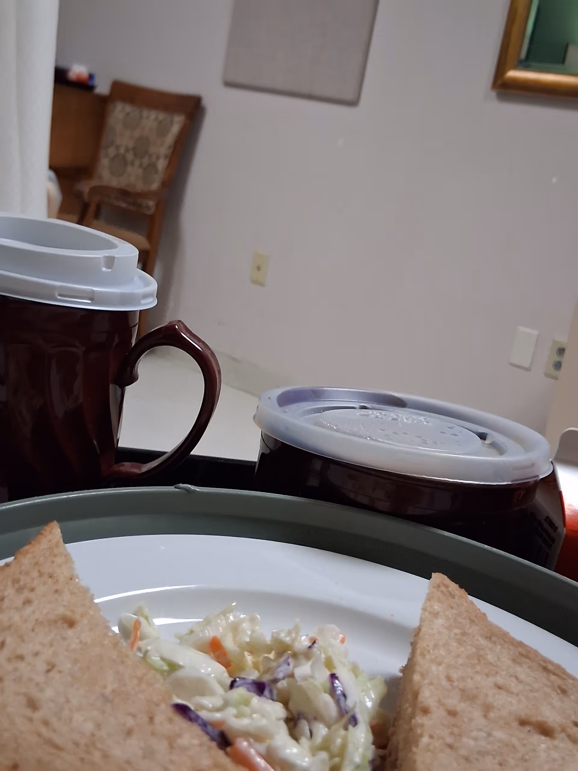 Tray of salad and toast with coffee cups on a dining table in a care facility.