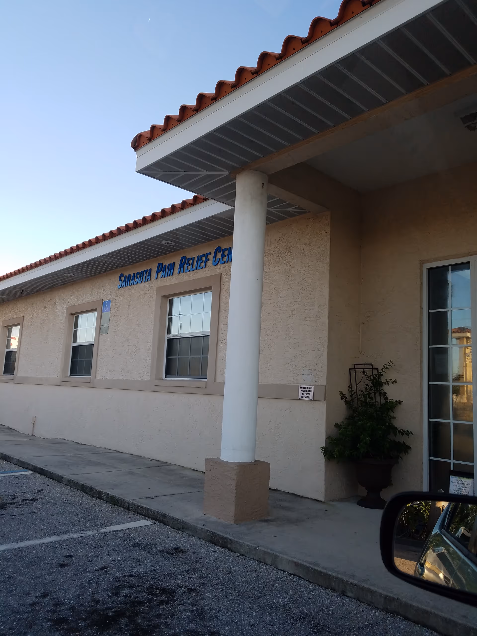 Exterior view of Sarasota Pain Relief Centers building with a column, windows, and entrance.