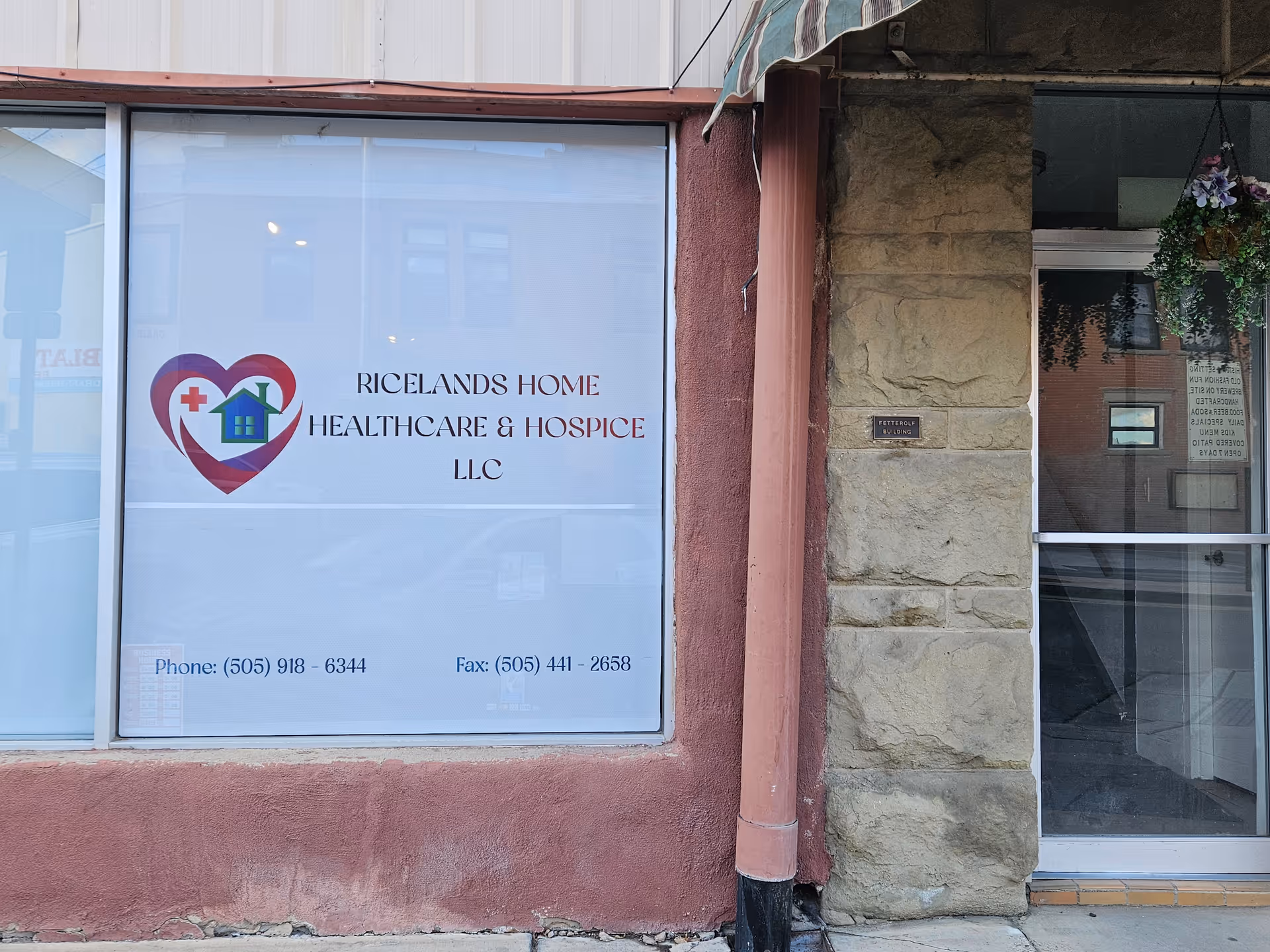 Storefront signage for Ricelands Home Healthcare & Hospice LLC, glass windows, stone entrance.