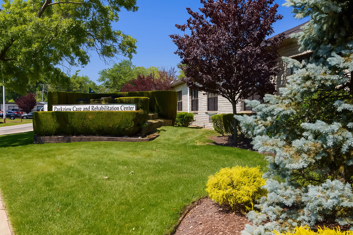 Exterior view of Parkview Care and Rehabilitation Center with a manicured lawn and sign.