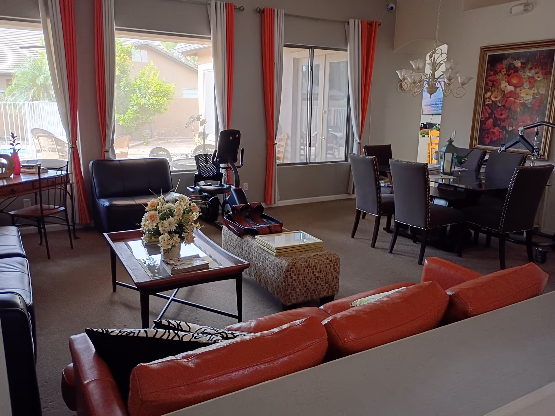 Interior living room with red leather sofas, coffee table, and adjoining dining area.
