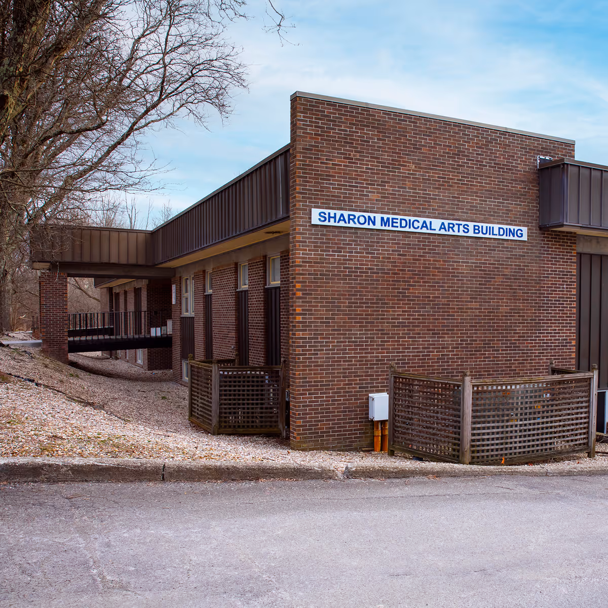 Brick exterior of Sharon Medical Arts Building with a blue sign.