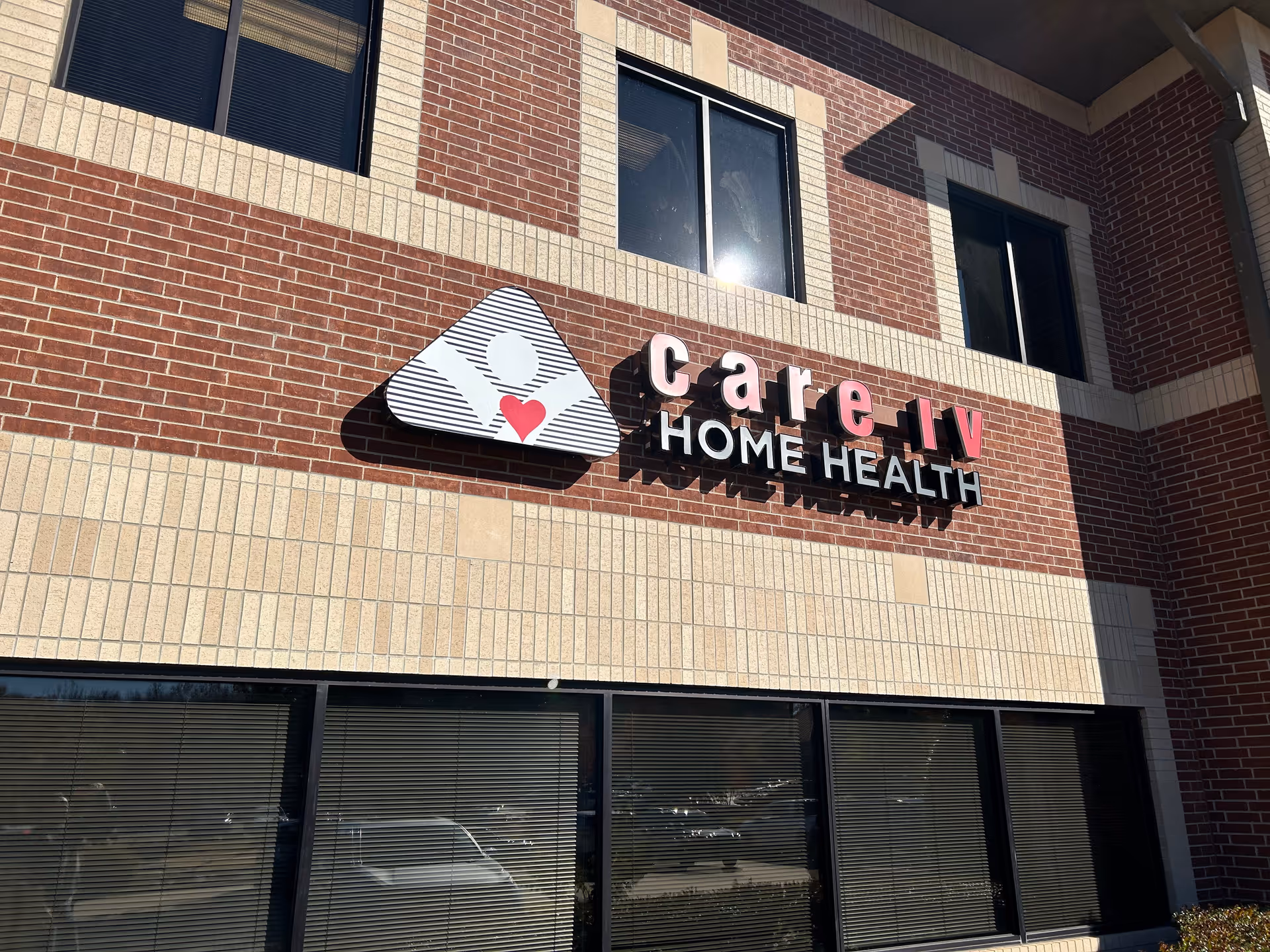 Exterior view of Care IV Home Health building with brick facade and sign.