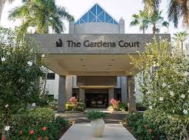 Front entrance of The Gardens Court with tropical landscaping