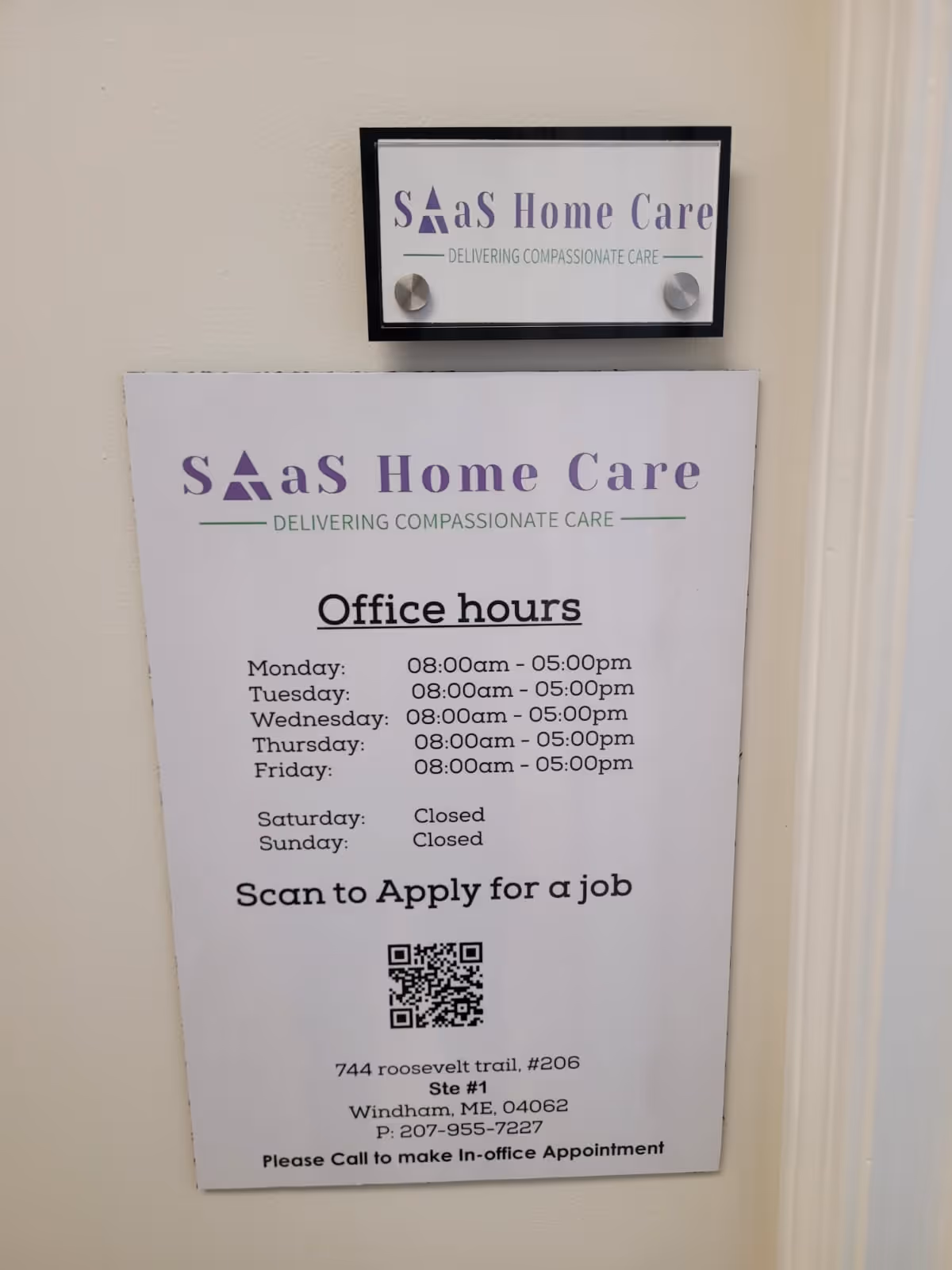 Interior wall with two SaaS Home Care signs and office hours poster.