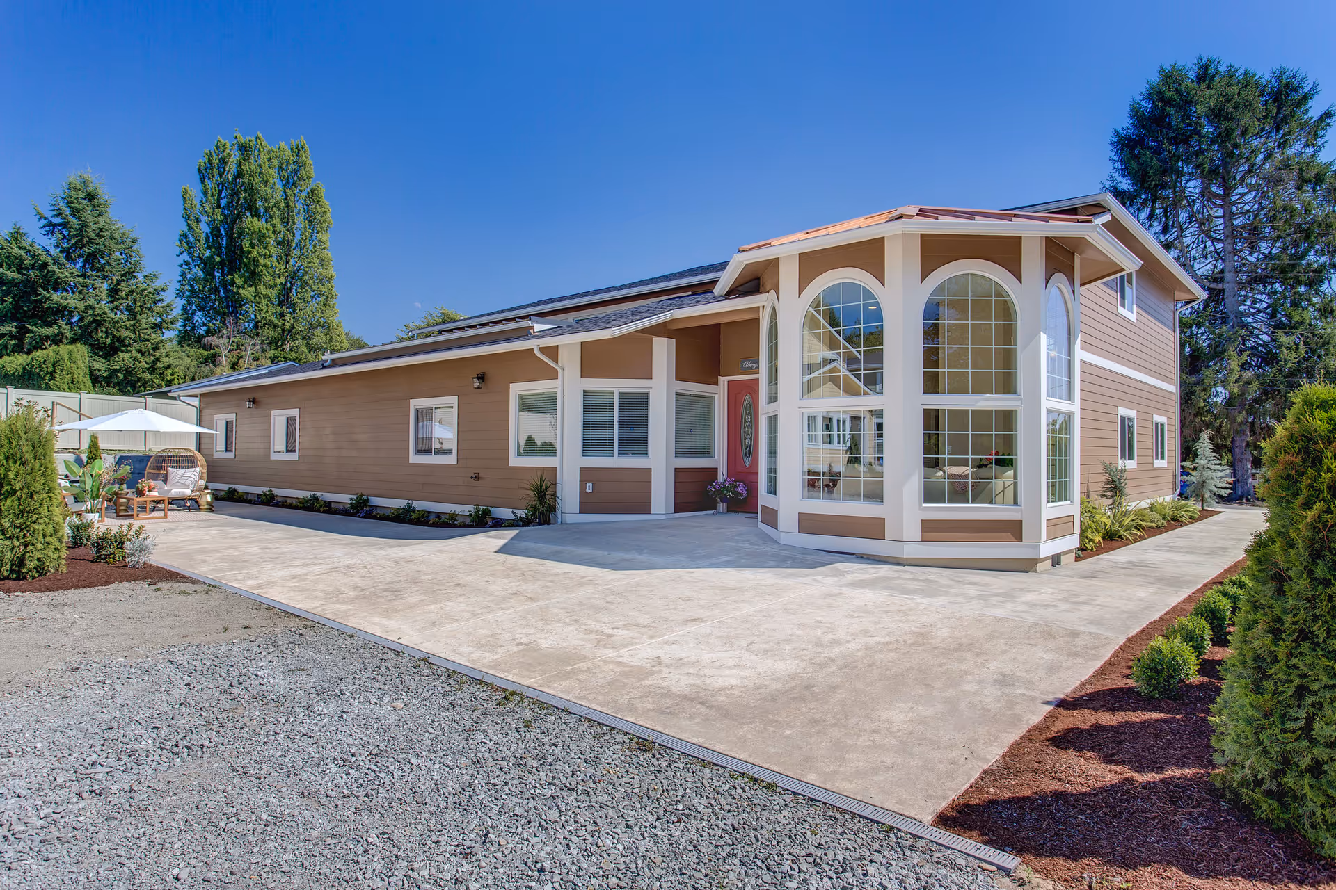 Front exterior of Angelwings Assisted Living with arched windows and a concrete entry.