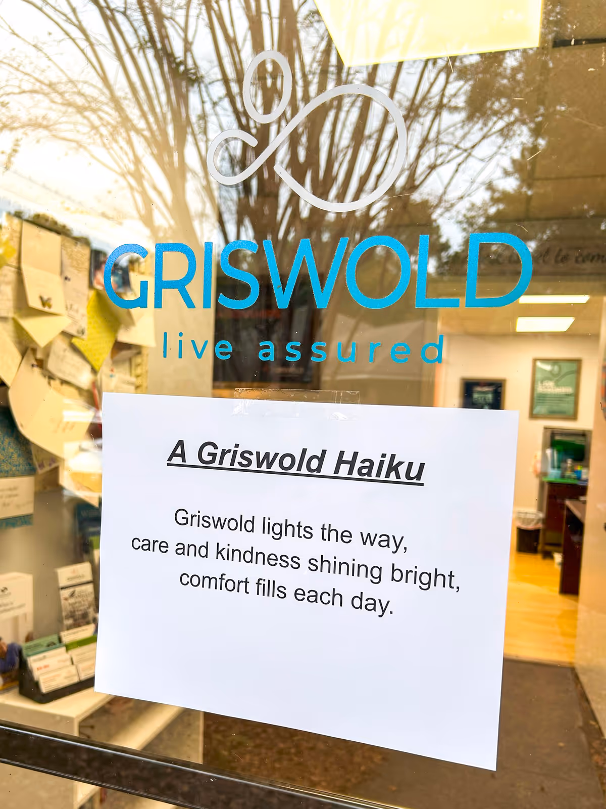 Glass storefront with Griswold sign and a posted haiku on a white sheet.