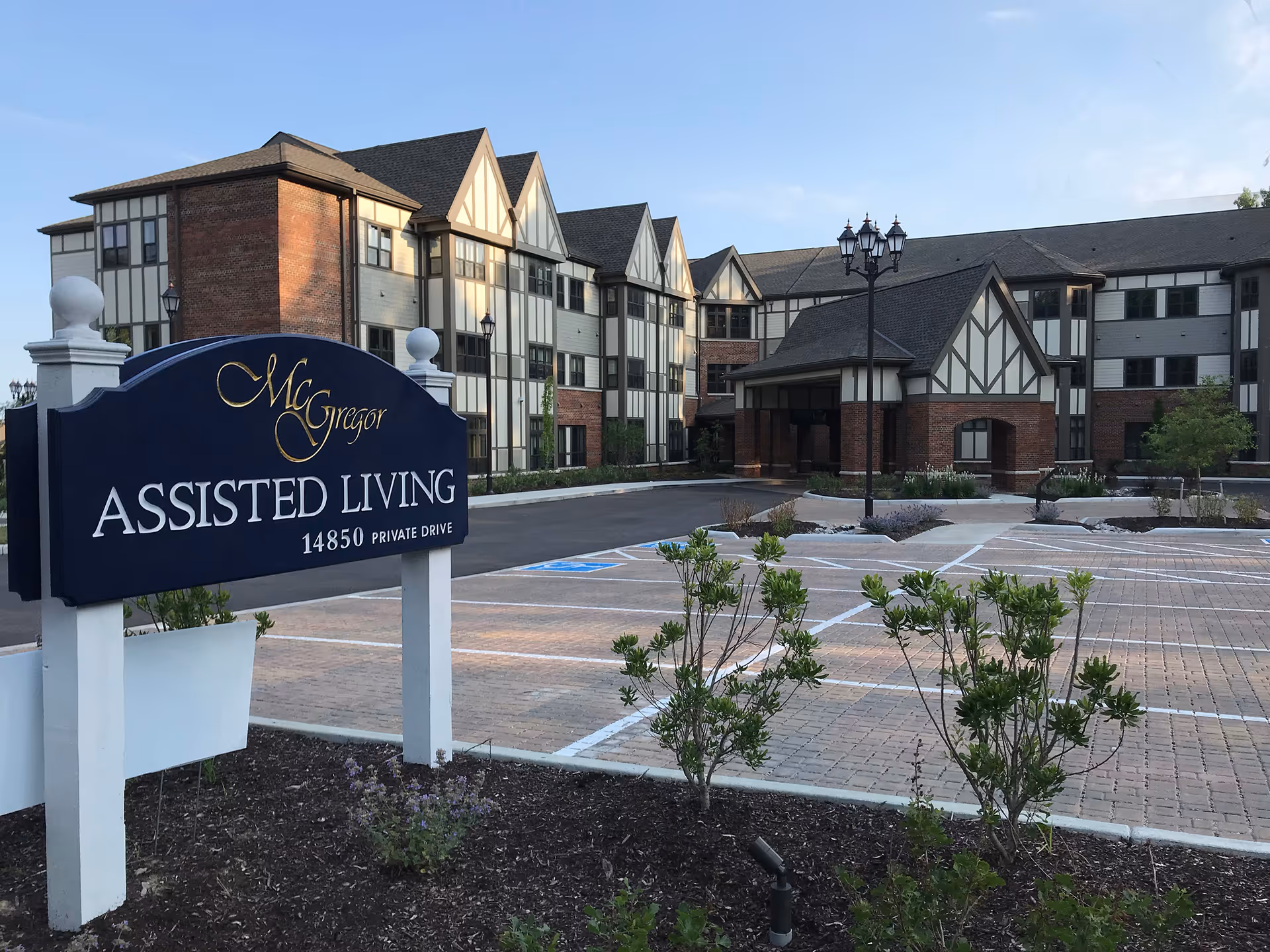 Exterior view of McGregor Assisted Living building with a large front sign and parking area.