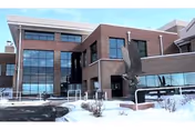 Exterior view of Spanish Peaks Veterans Community Living Center, brick building with large windows and snow.