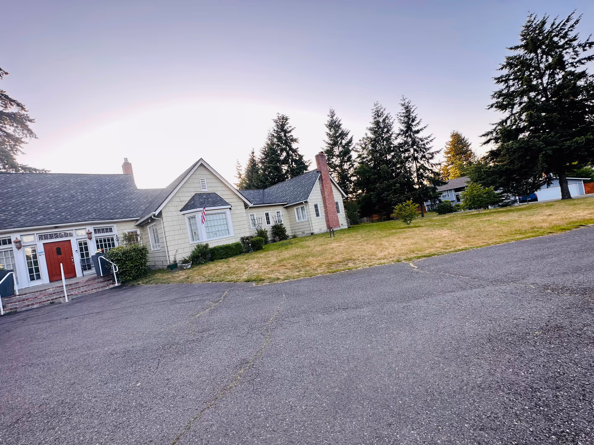 Exterior view of Sanders Estates Adult Family Home, a single-story building with a red front door.
