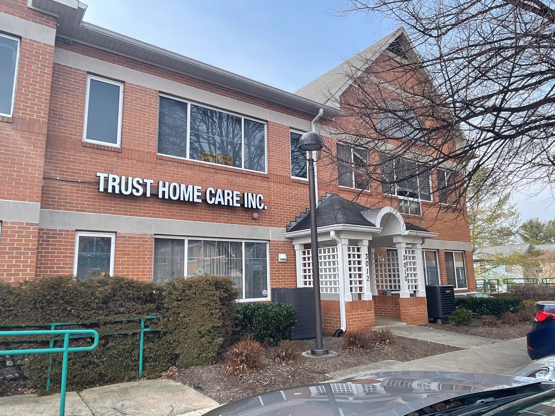 Brick two-story building with Trust Home Care Inc. sign and a covered entrance in front.